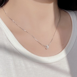 Détail du collier donut en argent 925 porté au cou montrant la brillance