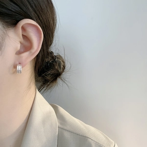 Gros plan de boucles d'oreilles créoles triple couche en argent avec texture martelée