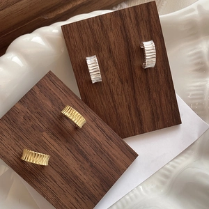 Detail of S925 sterling silver ruffled C-shape earrings in gold and silver finish