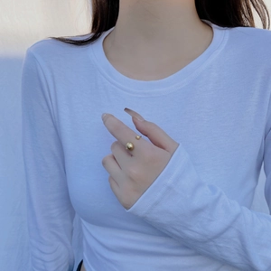 Detailed view of matte golden double bead open ring worn on index finger