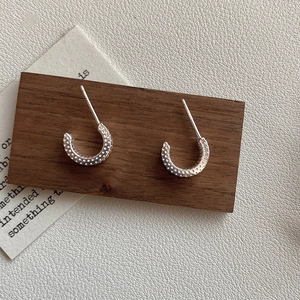 Detailed close-up of S925 sterling silver C-shaped stud earrings with dotted texture