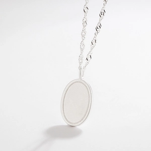 Detail of matte 925 sterling silver oval pendant with twisted water wave chain necklace