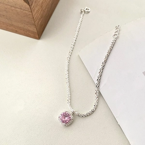Vue détaillée d'une chaîne en argent avec pendentif rose serti de strass brillants