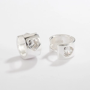 Macro view of S925 sterling silver hoop earrings with heart-shaped cubic zirconia stones