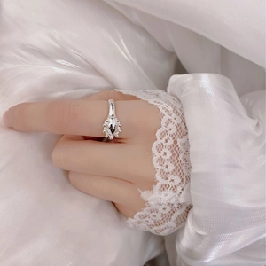 Close-up of S925 sterling silver flower crown ring worn on hand with lace background