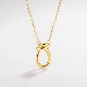 Detailed view of a gold knot pendant necklace with minimalist slim chain design