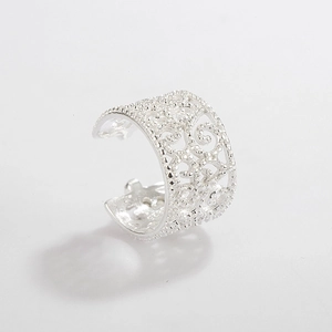 Detailed macro view of S925 sterling silver ear cuff with hollow filigree flower pattern