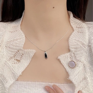 Minimalist S925 silver necklace featuring an oval black agate pendant on a model neck