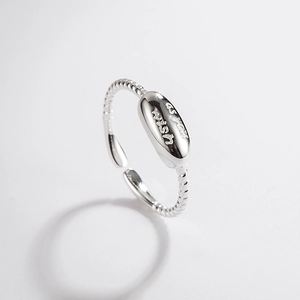 Macro detail of silver twist ring with oval tag engraved as you wish text