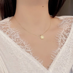 Gros plan du collier pendentif pièce d'or avec gravure La lune et bord torsadé