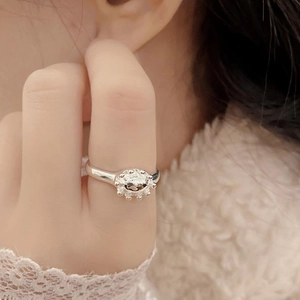 Vintage S925 sterling silver oval crown flower ring worn on a finger with warm lighting