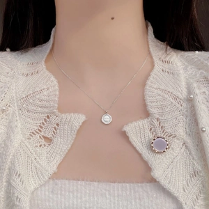 Collier en argent sterling 925 avec pendentif rond gravé porté par un mannequin élégant