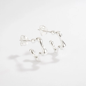 Détail de boucles d'oreilles en argent 925 avec texture ondulée et poinçon officiel