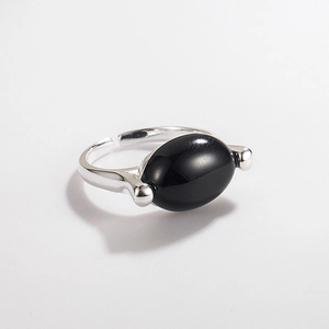 Detail view of oval black onyx gemstone on adjustable 925 silver minimalist open ring