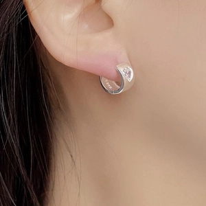 Close-up of S925 sterling silver huggie earrings with heart-shaped zircon inlay