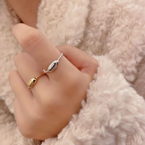 Close-up of gold and silver S925 sterling silver twist rings with oval engraved plates