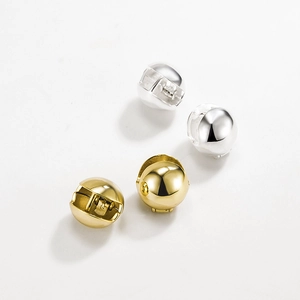 Détail du poinçon S925 sur des boucles d'oreilles boules minimalistes en or et argent