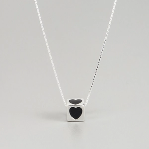 Close-up of S925 silver cube pendant with black heart on a box chain necklace
