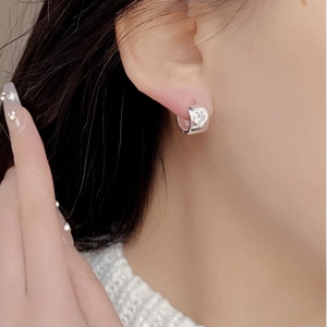 Close-up of S925 sterling silver heart zircon hoop earrings worn by a model