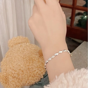 Detail of silver S925 beaded bracelet with oval polished beads on a woman wrist