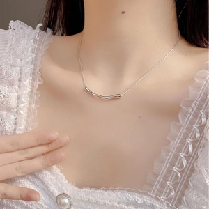 Gros plan d'un collier en argent 925 avec pendentif barre irrégulière porté au cou