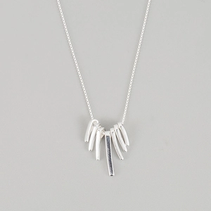 Macro detail of S925 sterling silver fan-shaped tassel necklace with polished bar pendant