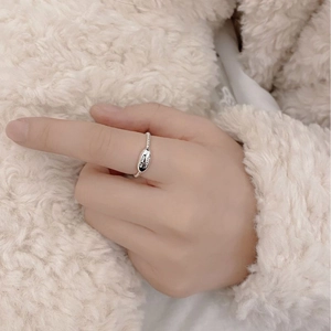 Detailed view of S925 silver beaded ring with oval engraved plate on finger