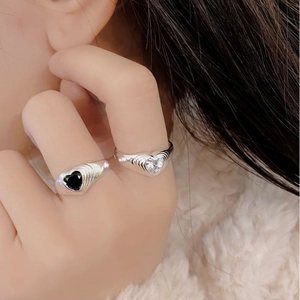 Macro shot of S925 silver rings with heart-shaped black and clear zircon stones
