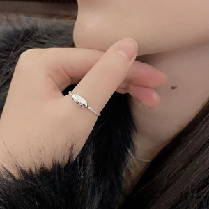 Minimalist S925 sterling silver twist ring with oval tag worn on model finger