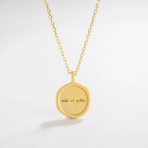 Close-up of gold coin pendant with All is Well engraving on a 925 silver chain