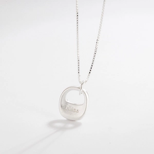 Close-up of matte silver 'bliss' pendant on a delicate box chain against a white backdrop