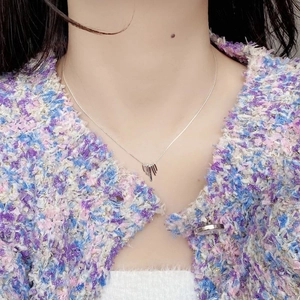 Detail of S925 sterling silver fan tassel necklace with irregular molten pendant on a model