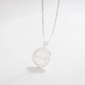Detailed view of 925 silver pendant necklace with 'all is well' engraving on round charm
