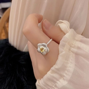 Detailed close-up of a silver flower ring featuring a yellow zircon and beaded band