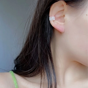 Detailed view of S925 sterling silver ear cuff with hollow floral pattern on a female ear