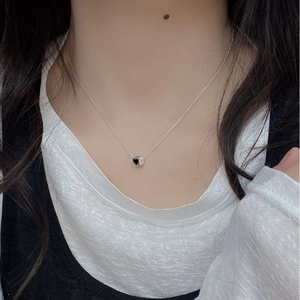 Detail of S925 sterling silver chain necklace featuring black heart cube pendant on neck