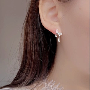 S925 sterling silver ribbon bow earrings with cubic zirconia on a female model