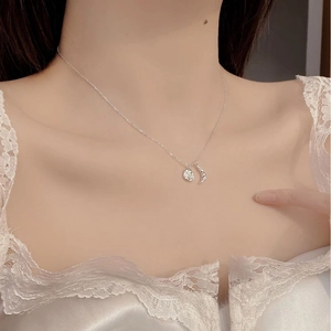 Close-up of 925 silver crescent moon and pearl pendant necklace on model collarbone