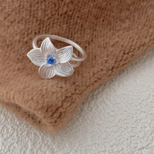 Elegant S925 silver hibiscus flower ring featuring a blue gemstone and brushed petals