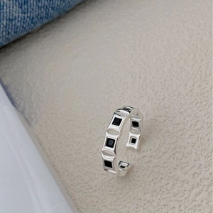 Detailed view of S925 silver adjustable ring with square black zircon on textured fabric