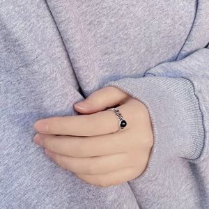 Macro shot of retro sterling silver chain ring with round black onyx stone on finger