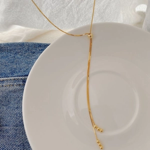 Dettaglio collana a Y regolabile in argento S925 placcato oro con catena box e nappe