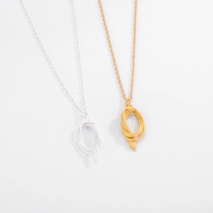 Close-up of gold and silver S925 sterling silver necklaces with matte knotted pendants