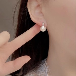 Elegant 925 sterling silver stud earrings with high-luster round white pearls on model