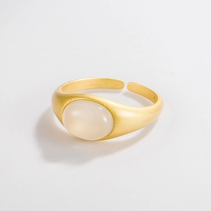 Macro view of matte gold adjustable ring featuring an oval milky white chalcedony stone