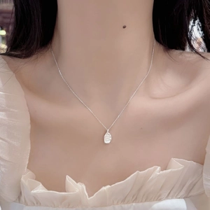 Detail of irregular matte silver pendant on a thin S925 sterling silver chain