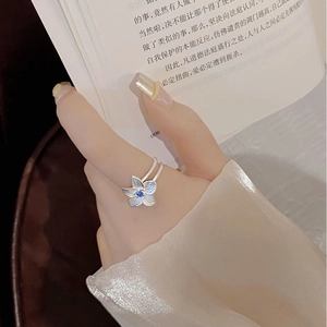 Detail of S925 silver flower ring with blue gemstone and elegant brushed texture