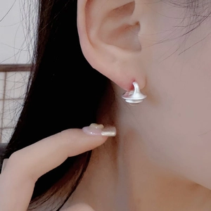 Gros plan de boucles d'oreilles minimalistes en argent avec finition mate