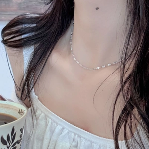 Detail of S925 sterling silver lip-link chain worn on a neck for a minimalist style