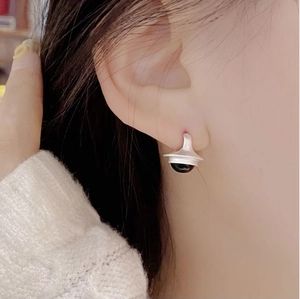 Détail macro d'une boucle d'oreille vintage en argent avec finition mate et agate noire
